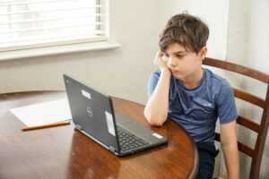 Distraught student learning to type at a table.